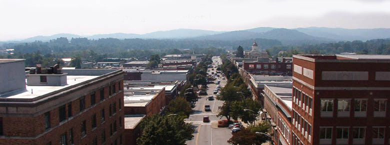 An aerial view of downtown Hendersonville's Main Street, with the Blue Ridge Mountains in the background.